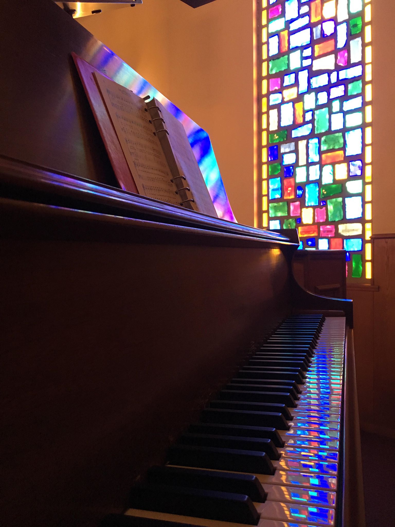 Stained glass reflecting on piano keys